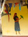 Painting of Kuna woman with ubiquitous green parrot pet